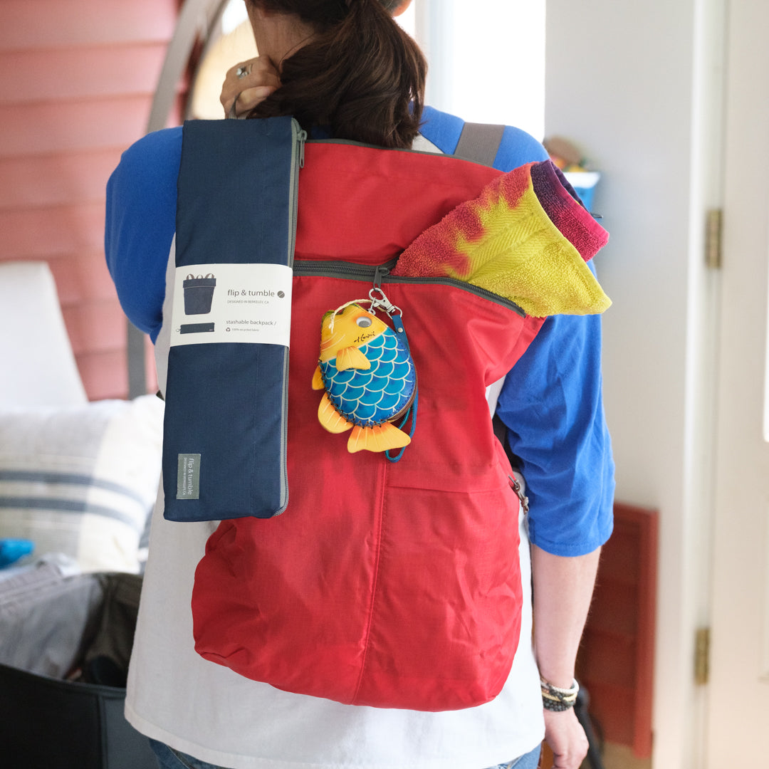 Person wearing a backpack and a fish-shaped keychain.