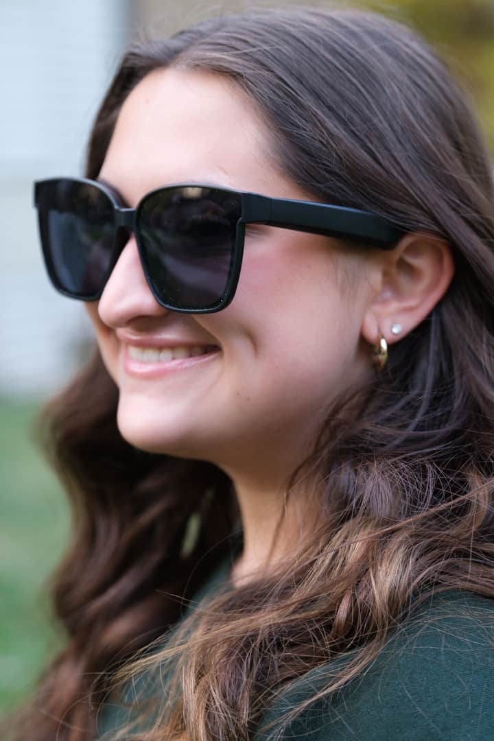 Woman wearing black sunglasses with a blurred background