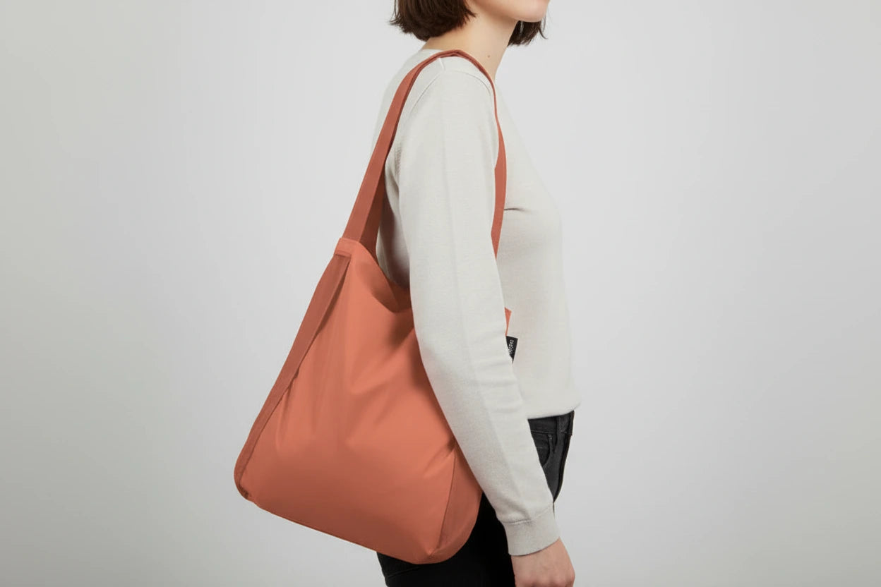 Terracotta colored tote bag from notabag on  woman's shoulder