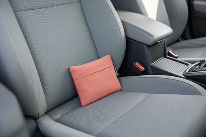 Terracotta colored pouch on a car seat