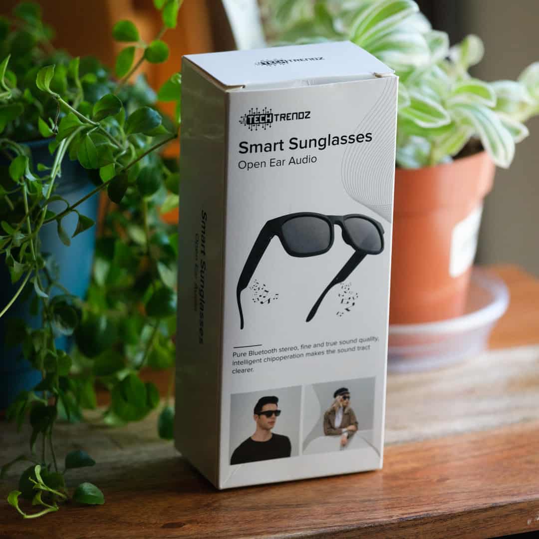 Box of TechTrendz Smart Sunglasses on a wooden surface with plants in the background