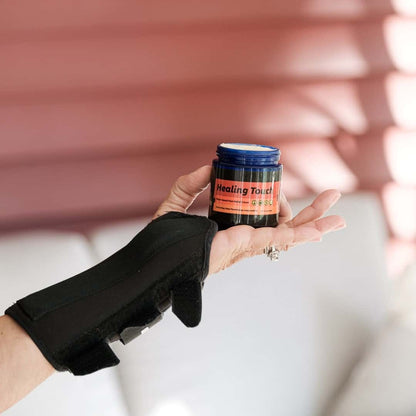 Person holding a jar labeled 'Healing Touch' with a blurred background
