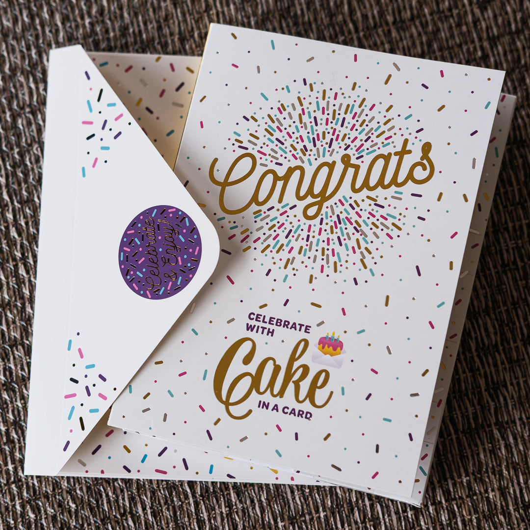 Greeting card with 'Congrats' and 'Celebrate with Cake in a Card' text, featuring colorful sprinkles on a textured surface.