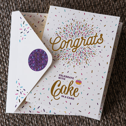 Greeting card with 'Congrats' and 'Celebrate with Cake in a Card' text, featuring colorful sprinkles on a textured surface.