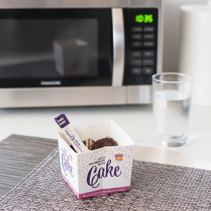 Box of instant cake with a mixing spoon on a textured surface
