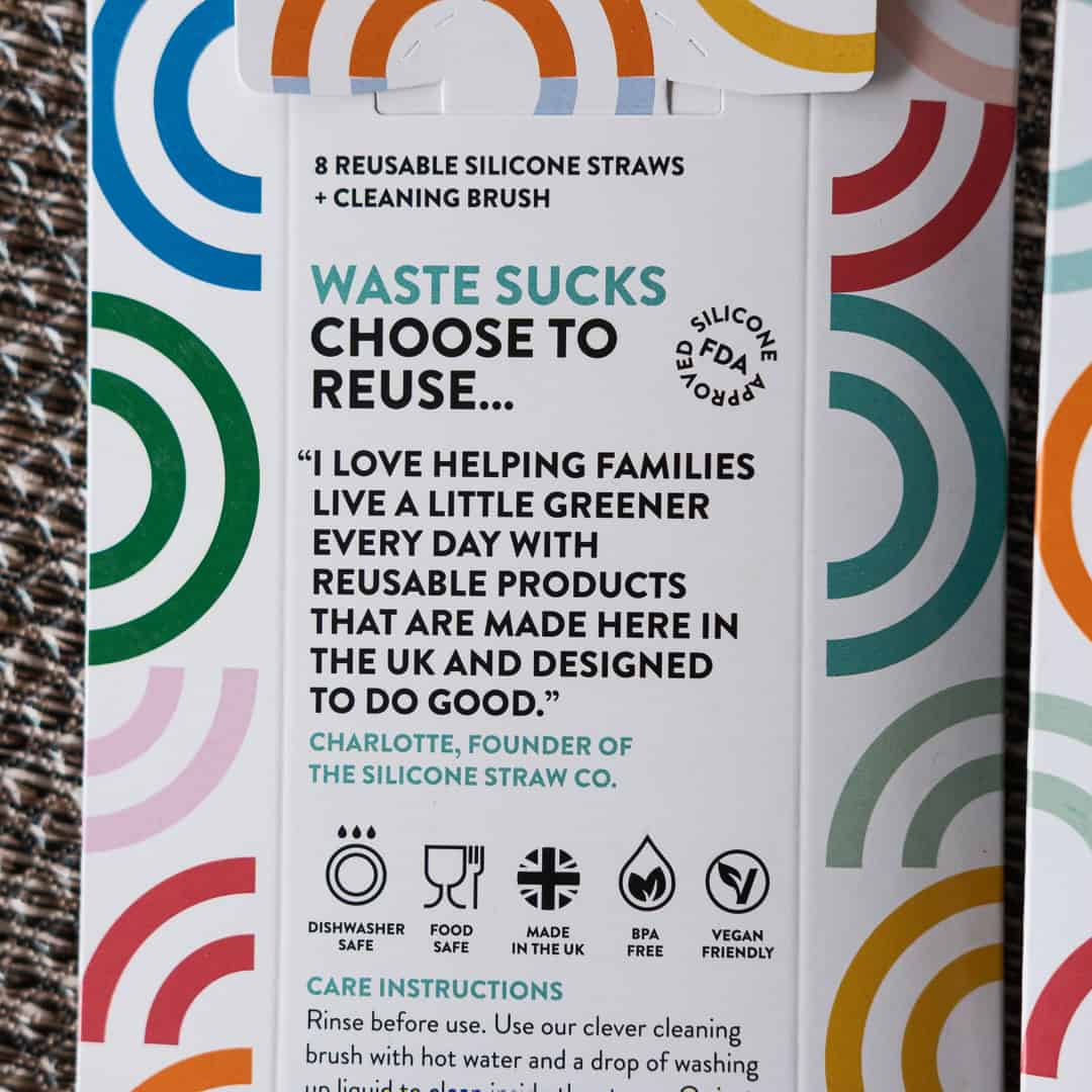 Packaging of reusable silicone straws with colorful design and text on a textured surface.
